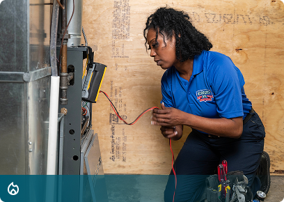 Heating CTA Heating services: Academy Air technician testing wiring at a furnace